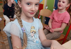 Dziewczynki z grupy „Misie” podczas wykonywania makijażu z okazji Dnia Kobiet.