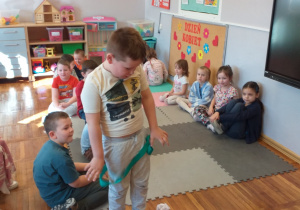 Chłopiec mierzy się z jedną z konkurencji - przechodzi przez szarfę.