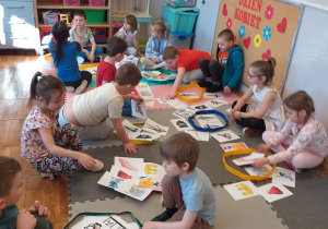 Dzieci podzielone na grupy segregują rekwizyty królewny i rycerza.