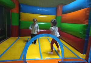 Dzieci skaczą na dmuchańcu.