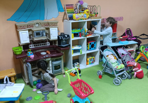 Dziewczynka z chłopcem bawi się w kąciku kuchennym