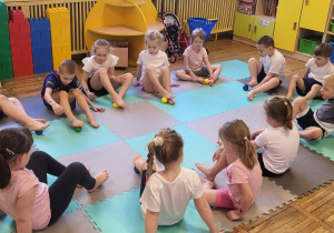 Dzieci ćwiczą stopy z wykorzystaniem piłeczek sensorycznych.