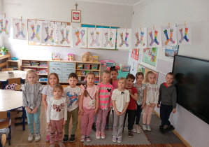Dzieci z grupy Odkrywcy pozują z kolorowymi skarpetkami z okazji Dni Kolorowej Skarpetki.