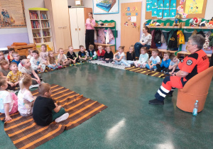 Ratownik medyczny mówi dzieciom jak można komuś pomóc przed przyjazdem pogotowia ratunkowego.