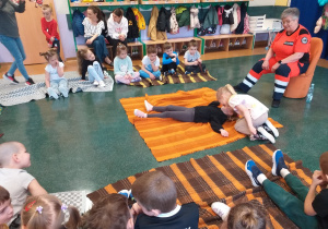 Dziecko ćwiczy sprawdzanie przytomności osoby poszkodowanej.