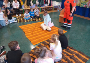 Dziecko wykonuje czynności ratujące życie na fantomie.