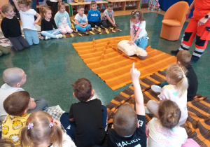 Dziecko wykonuje czynności ratujące życie na fantomie.