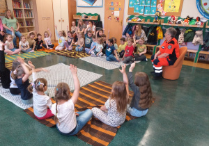 Dzieci zgłaszają się do odpowiedzi na pytania ratownika medycznego.