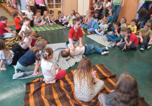 Dziecko ćwiczy układanie osoby poszkodowanej w pozycji bocznej ustalonej.