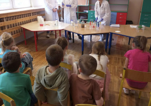 Dzieci obserwują eksperymenty z wodą.