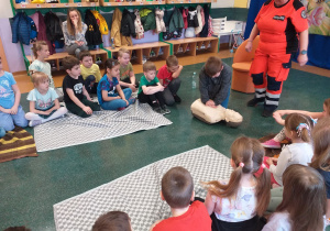 Dziecko wykonuje czynności ratujące życie na fantomie.