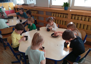 Na zdjęciu widzimy dzieci z grupy Odkrywcy podczas siania owsa.