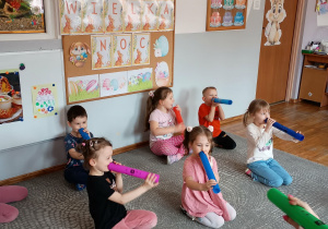 Dzieci grają na bum bum rurkach.