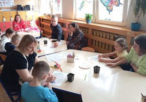 Kolaż przedstawia Smerfy oraz ich rodziców wykonujących wspólnie prace podczas warsztatów wielkanocnych