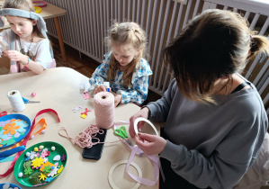 Dziewczynka z grupy „Misie” wraz ze swoją mamą wykonują wianek wielkanocny.