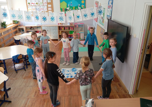 Dzieci z grupy Odkrywcy pozują z plakatem związanym z obchodami Dnia Świadomości Autyzmu.