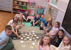 Zdjęcie przedstawia dzieci grające w grę Memory związaną z marchewką.