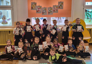 Dzieci z grupy Żabki pozują do zdjęcia z dyplomami i czekoladami.