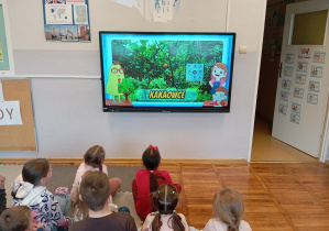 Dzieci z grupy odkrywcy oglądają film edukacyjny o pochodzeniu czekolady.