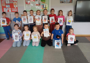 Dzieci z grupy odkrywcy pozują z pracą plastyczną z okazji Dnia Czekolady.