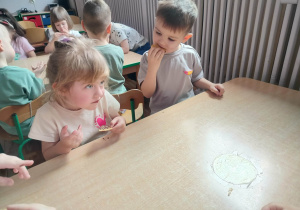 Dzieci jedzą słodkie przekąski.