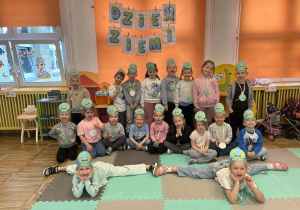 Dzieci pozują do zdjęcia z opaskami i medalami z okazji Dnia Ziemi.