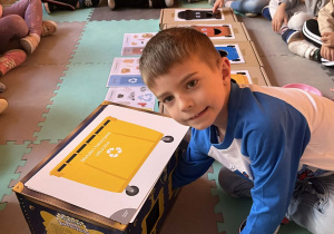 Chłopiec segreguje śmieci.