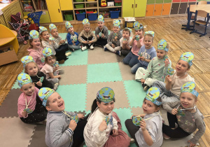 9.Dzieci pozują do zdjęcia z opaskami i medalami z okazji Dnia Ziemi.