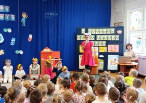 Pani pielęgniarka opowiada dzieciom o zdrowych nawykach żywieniowych.