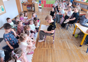 Dzieci z klasy pierwszej czytają bajkę kolegom i koleżankom z przedszkola.