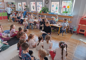 Dziewczynka czyta bajkę wszystkim dzieciom.