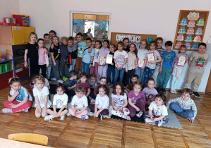 Dzieci z grupy Stokrotki z uczniami klasy 1 podczas wspólnego czytania.