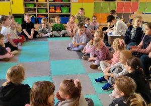 Dzieci z grupy Żabki słuchają bajki czytanej przez uczniów z klasy Id.