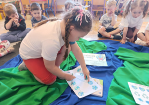 Dziewczynka wykonuje zadanie dotyczące postaw ekologicznych.