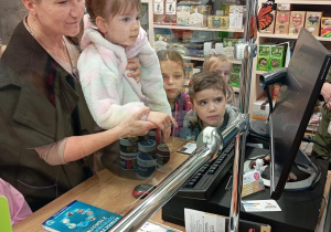 Dzieci z grupy Odkrywcy zapoznają się z kasą w Sklepie ze Zdrową Żywnością.