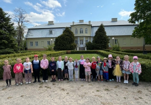 Dzieci pozują do wspólnego zdjęcia na tle Muzeum Regionalnego w Bełchatowie.