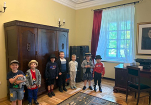 Chłopcy pozują do zdjęcia na tle eksponatów muzealnych.