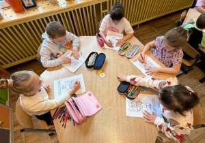 „Żabki” wykonują pracę plastyczną z okazji Dnia Bibliotekarza.