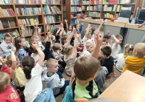 Dzieci odpowiadają na pytania zadawane przez panią bibliotekarkę dotyczące wiedzy o bibliotece.