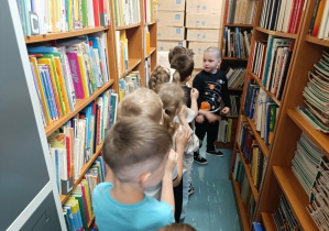 Przedszkolaki zwiedzają bibliotekę szkolną.