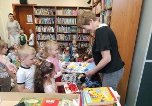 Dzieci wręczają upominek pani bibliotekarce.