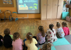 Przedszkolaki z grupy „Żabki” oglądają film edukacyjny o pracy w bibliotece.