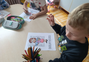 Dzieci z grupy „Misie” kolorują obrazki z okazji Dnia Bibliotekarza.