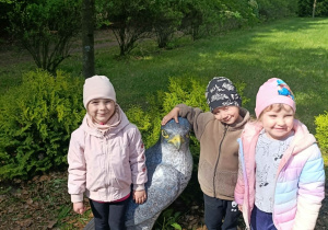 Dzieci pozują do zdjęcia z ptakiem