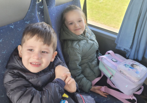 Dziewczynka i chłopiec siedzą w autobusie i czekają na odjazd.