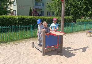 Chłopcy pozują do zdjęcia na placu zabaw.