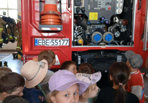 Dzieci z grupy „Misie” i „Odkrywcy” oglądają wnętrze wozu strażackiego.