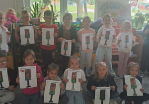 Dzieci z grupy Motylki pozują do zdjęcia z wykonanymi przez siebie sygnalizatorami świetlnymi.