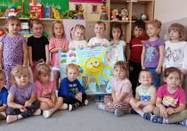 Przedszkolaki z grupy Biedronki prezentują samodzielnie przygotowany plakat przedstawiający zasady bezpieczeństwa w trakcie letniego odpoczynku.