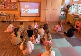 Dzieci z grupy Żabki oglądają film edukacyjny ,,Bezpieczne wakacje w górach i nad morzem”.